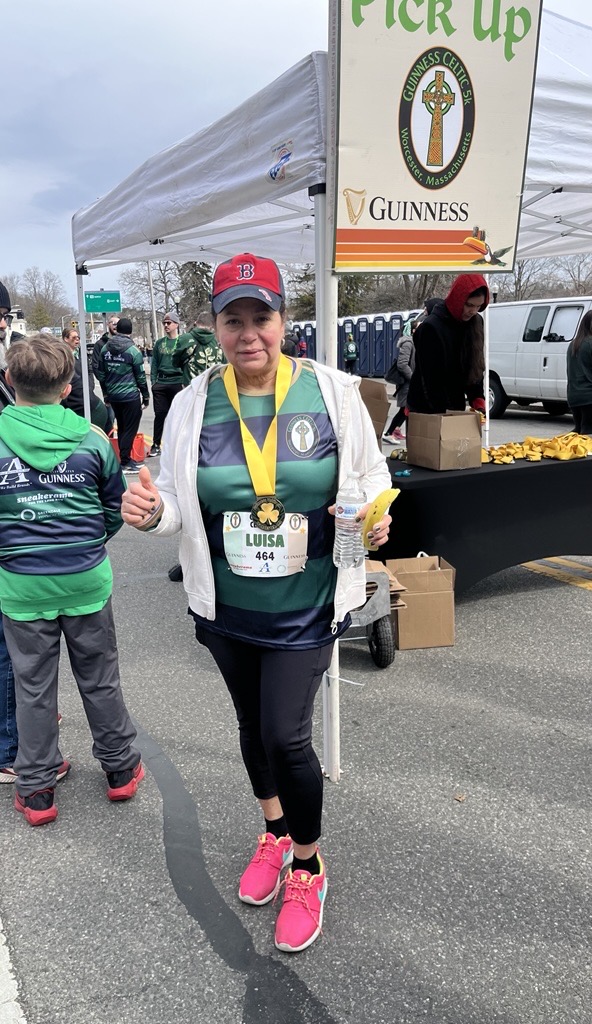 Woman in medal, athletic attire, smiling