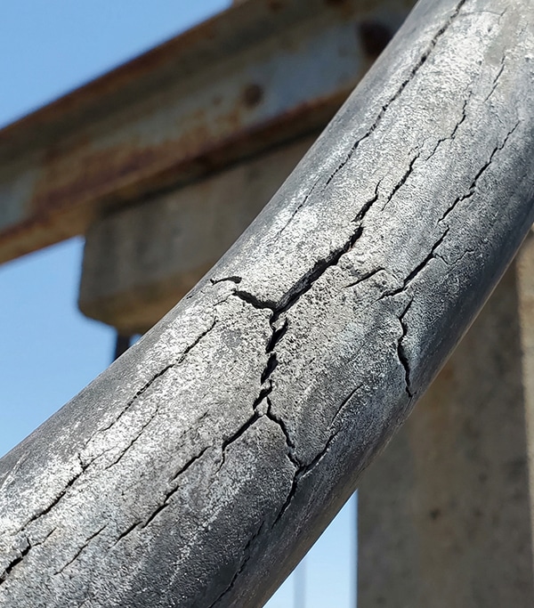 Cracked outdoor cable jacket showing UV degradation and thermal cycling damage on tower-mounted obstruction lighting cable
