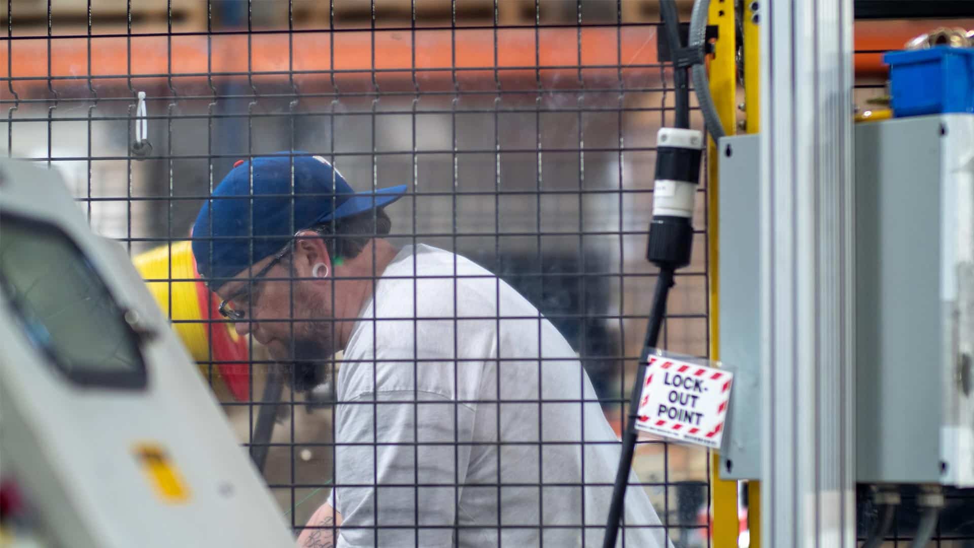 Worker behind safety mesh in factory