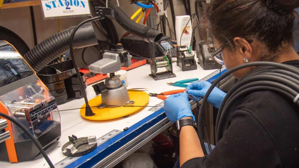 Person soldering at a workbench