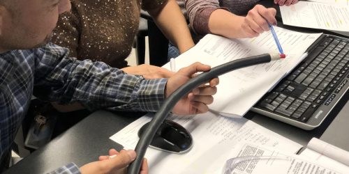 People collaborating with documents and equipment